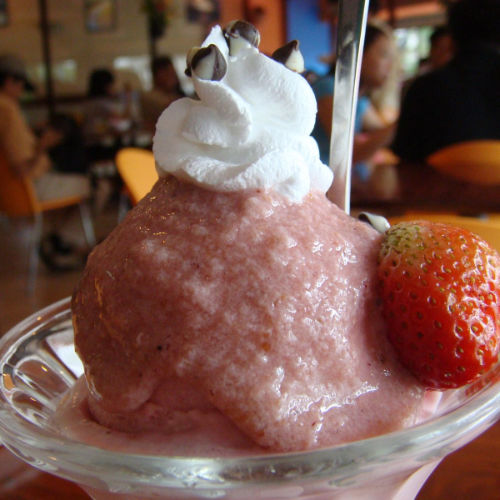 Strawberry ice cream with whip cream and a strawberry